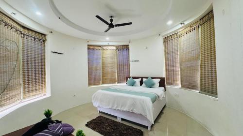 a bedroom with a bed in a room with windows at Rajvin Heavens Resort in Bhīm Tāl