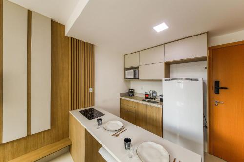 a kitchen with a white refrigerator and a counter at Queridinho do São Mateus com ar - lado da igreja in Dom Bosco