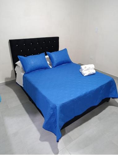 a blue bed with blue sheets and blue pillows at Quindio Mio in Filandia