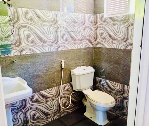 a bathroom with a toilet and a sink at Sampath Grand Hotel in Mawanella