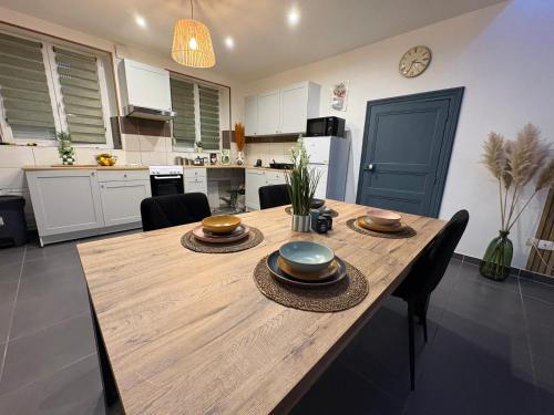 a kitchen with a wooden table with plates on it at La Dryade in Braux