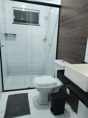 a bathroom with a toilet and a shower and a sink at Casa Paraíso Piscina Aquecida e Pet Friendly in Sinop