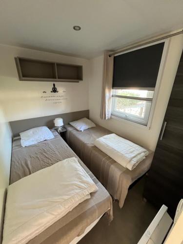 two beds in a small room with a window at VI05 Village 05 in Vias