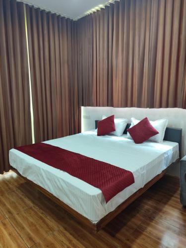a bedroom with a large bed with red pillows at Spice Garden Clove Villa in Batheri