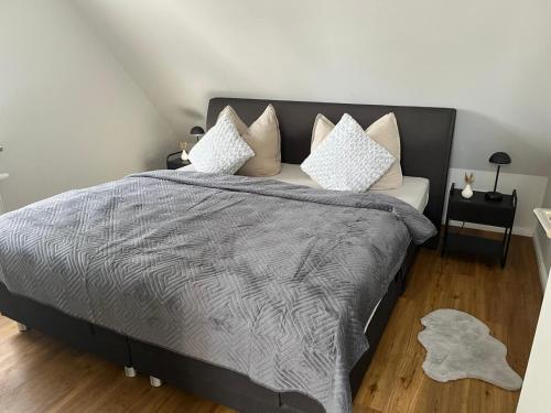 a bedroom with a large bed with white pillows at Waldnest am Meer in Varel