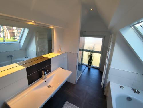 a bathroom with a sink and a large mirror at Waldnest am Meer in Varel