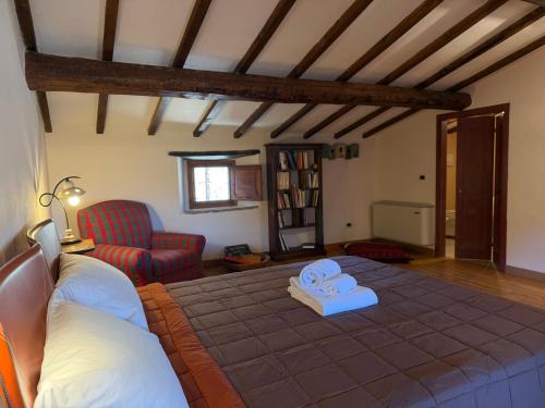 a living room with a bed and a chair at Campanile N1 in Montemerano