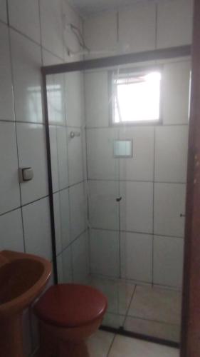 a bathroom with a shower with a toilet and a window at Casa Próxima ao Centro in Itajubá