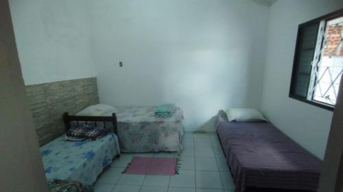 a bedroom with two beds and a window at Casa Próxima ao Centro in Itajubá