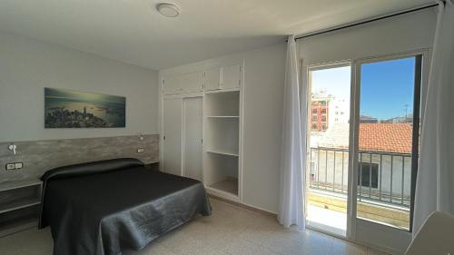 a bedroom with a bed and a large window at Hotel Congra in Pilar de la Horadada