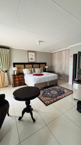 a bedroom with a bed and a table in it at Dakarai B & B in Thulamahashi