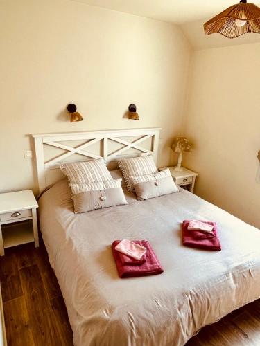 a bedroom with a large bed with two towels on it at Villa Chez Laurette - Baie de Somme en famille - 4 à 6 personnes - piscine - parking privé - plage à 5 min in Le Crotoy