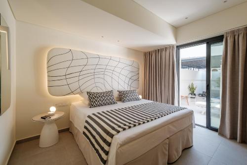 a bedroom with a large bed and a balcony at Noera in Skiathos