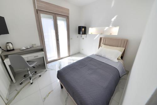 a bedroom with a bed and a desk and a window at Gioia e Relax di ZR in Rho