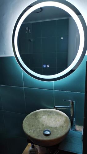a bathroom with a sink and a large mirror at SkyhighRetezat in Clopotiva