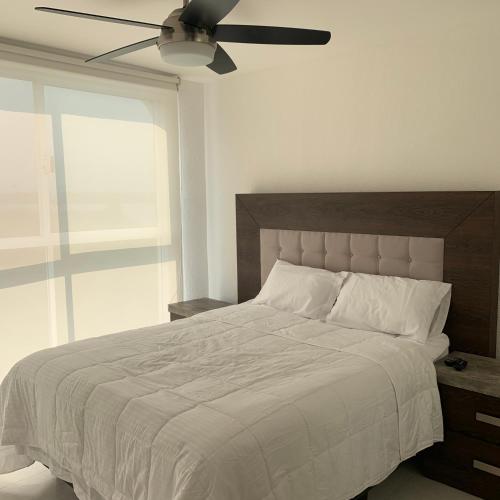 a bedroom with a large bed with a ceiling fan at Hermoso departamento en Tequesquitengo alberca jacuzzi y acceso al lago in Tequesquitengo
