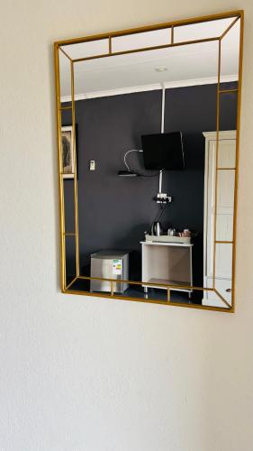 a mirror hanging on a wall in a room at Dakarai B & B in Thulamahashi