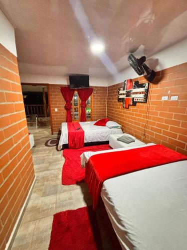 a bedroom with two beds and a brick wall at La morada in Guayabal