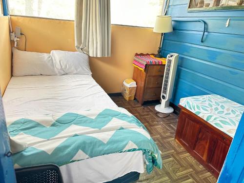 a bedroom with a twin bed and a small table at The Howler Jungle House and Cabanas in Belize City