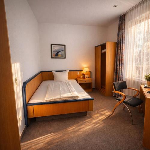 a bedroom with a bed and a desk and a chair at Hotel Bölke in Wunstorf
