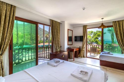 a bedroom with a bed and a balcony at Hotel Ekincik in Ekincik