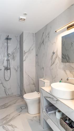 a white bathroom with a sink and a toilet at Basil Leaf - Minimal View Retreat in Gonia