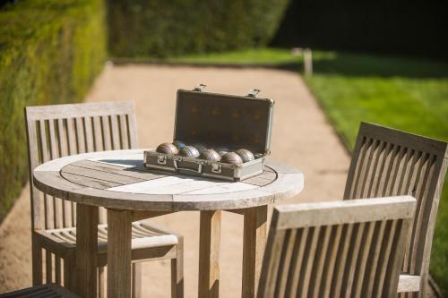 a table with a suitcase on it with two chairs at Begijnhof Hotel in Leuven