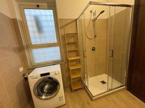 a washing machine in a bathroom with a shower at CAERE RoGi House in Cerveteri