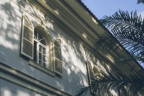 a building with a window and a palm tree at Hotel del Parque in Guayaquil