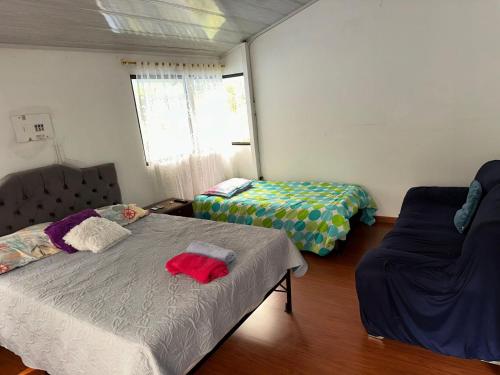 a bedroom with two beds and a couch at Cabañas Bosque Encanto - Jacuzzi in San Francisco
