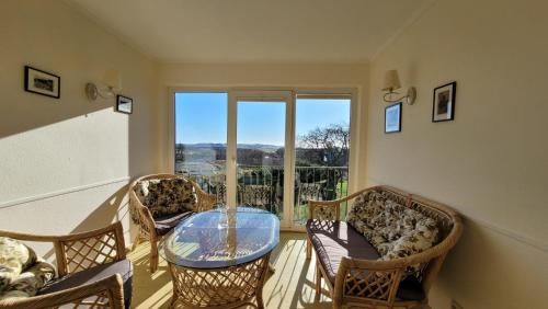 a living room with a glass table and chairs at Ferienwohnungen Meerblick Herde in Göhren