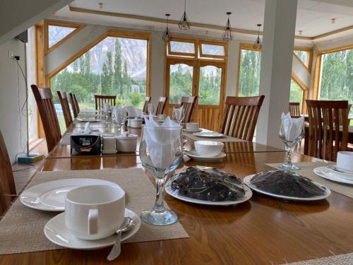 a wooden table with plates and glasses on it at Montvale Resort in Pasu