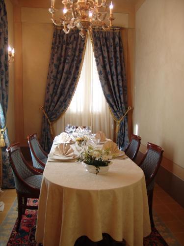 a dining room table with chairs and a chandelier at Castello Montegiove in Fano