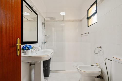a white bathroom with a sink and a toilet at Villa Vineyard by Homie in Câmara de Lobos
