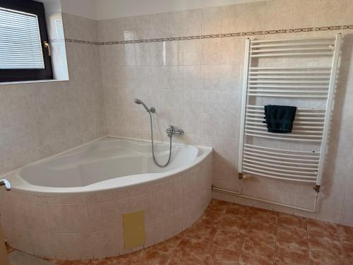 a bath tub in a bathroom with a window at Penzion U Růže in Sezimovo Ústí