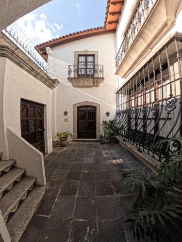 an empty courtyard of a house with a balcony at Avicena Hotel Boutique in Cuernavaca