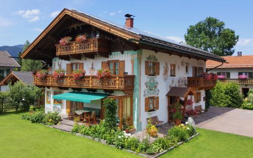 a house with a balcony with flowers on it at Ferienwohnung KARWENDEL in Krün