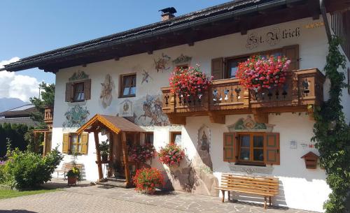 a building with flowers on the balcony and a bench at Ferienwohnung KARWENDEL in Krün