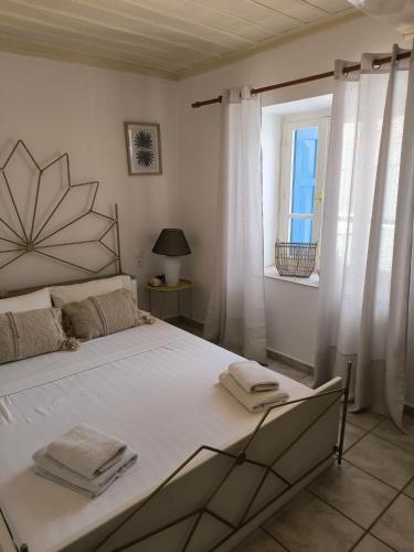 a bedroom with a large bed and a window at Reborn Project Plakes in Skiathos