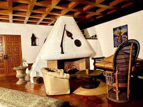 a living room with a fireplace with a couch and a chair at Avicena Hotel Boutique in Cuernavaca