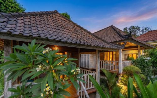 a house with a wooden deck in front of it at Bali Nusa Cottage in Nusa Lembongan