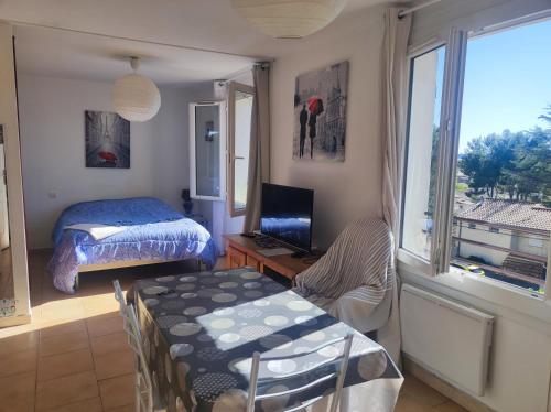 a bedroom with a bed and a desk with a television at Ingrid Mary in Nîmes