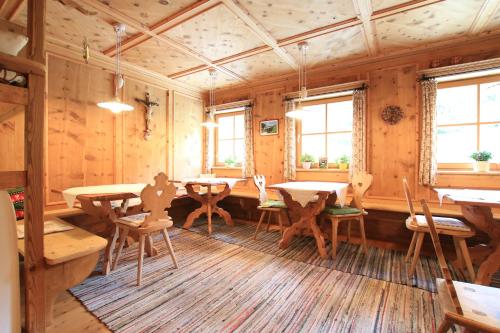 une salle à manger avec des murs et des tables en bois et des fenêtres dans l'établissement Paalhof, à Castelrotto
