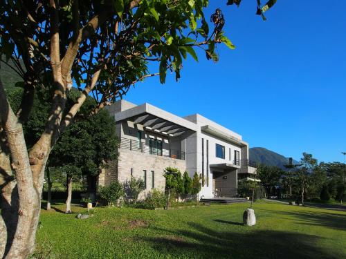 un edificio con un árbol delante de él en Viasea B&B, en Xiulin