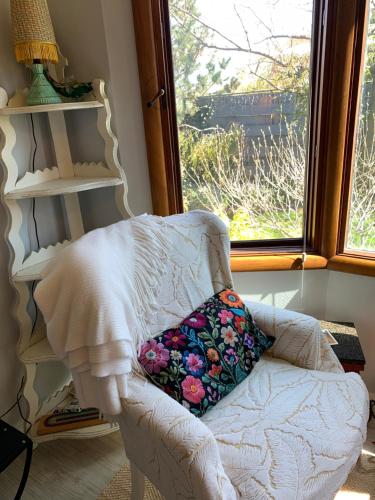 a white chair with a pillow sitting in front of a window at Riverhouse Hidden Gem in The Dalles