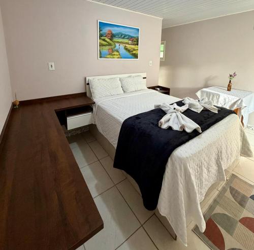 a bedroom with a bed with a black blanket at Harry World Parque Hotel in Curitibanos