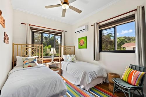 two beds in a bedroom with a ceiling fan at Pacific Beach 9 - Beachfront Condo, BBQ, pool, prime location, sleeps 4 in Potrero