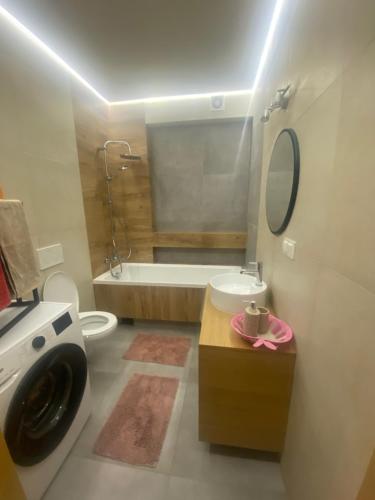 a bathroom with a tub and a toilet and a sink at DOM NA WYŁĄCZNOŚĆ- Odpoczynek w sercu Mazur in Miłki
