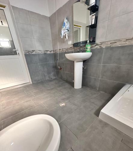 a bathroom with a white toilet and a sink at Bodini Mountain House in Peqin