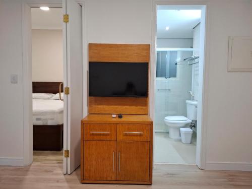 a bathroom with a television on a dresser with a toilet at Flat IMPECAVEL proximo aos Shoppings JK e Vila Olimpia in São Paulo